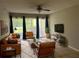 Bright living room features sleek leather furniture, modern ceiling fan, and sliding glass doors at 3270 S Semoran Blvd # 15, Orlando, FL 32822