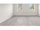 Bright bedroom featuring durable light wood flooring, two windows and white trim at 3749 Sw 131St St, Ocala, FL 34473
