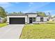 Charming single-story home featuring a modern design, black trim, and an attached two-car garage at 3749 Sw 131St St, Ocala, FL 34473