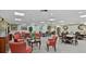 Large community room with patterned carpet, tables, chairs, and tasteful decor at 400 E Colonial Dr # 910, Orlando, FL 32803