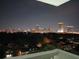 Balcony view of city skyline at night with lush trees and rooftops below at 400 E Colonial Dr # 910, Orlando, FL 32803