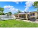 The backyard features a white fence, a lawn, a screened-in porch, a grill, and leads to a pool at 4015 Ibis Dr, Orlando, FL 32803