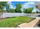 The backyard has a white fence surrounding it, a small area of grass, and a concrete path that leads to the pool at 4015 Ibis Dr, Orlando, FL 32803