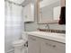 This updated bathroom features a shower with a toilet and a vanity with a neutral color palette at 4015 Ibis Dr, Orlando, FL 32803
