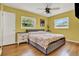 Bedroom featuring hardwood floors, yellow walls, ceiling fan, and natural light at 4015 Ibis Dr, Orlando, FL 32803
