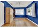 Cozy bedroom featuring hardwood floors, blue walls, and a ceiling fan at 4015 Ibis Dr, Orlando, FL 32803