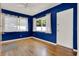 Bright bedroom with hardwood floors, blue walls, ceiling fan, and natural light at 4015 Ibis Dr, Orlando, FL 32803