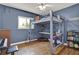 This blue bedroom has a lofted bed with a desk underneath, a window, hardwood floors, and a ceiling fan at 4015 Ibis Dr, Orlando, FL 32803