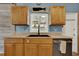 Kitchen featuring wooden cabinets, light countertops, black sink, and stainless steel dishwasher at 4015 Ibis Dr, Orlando, FL 32803