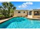 Backyard pool surrounded by lush landscaping, featuring a partial view of the house under a bright blue sky at 4015 Ibis Dr, Orlando, FL 32803