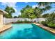 Inviting backyard pool with a concrete patio, white fence, and beautiful tropical landscaping at 4015 Ibis Dr, Orlando, FL 32803