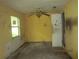 Bedroom with dirty walls, a dated ceiling fan, and a large un-screened window at 4231 Raleigh St, Orlando, FL 32811