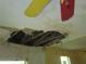 Damaged ceiling revealing roof support with deteriorated texture in a fixer upper house at 4231 Raleigh St, Orlando, FL 32811
