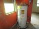 Obsolete water heater needing replacement next to a window in a run down home at 4231 Raleigh St, Orlando, FL 32811