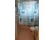 Small tiled bathroom featuring a toilet and a shower curtain with a beach themed pattern at 4351 Winding Oaks Cir, Mulberry, FL 33860