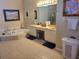 Bathroom features double sinks, a soaking tub, neutral tile, and coordinated decor at 4351 Winding Oaks Cir, Mulberry, FL 33860