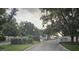 Gated entrance to a community surrounded by trees and lush landscaping at 4351 Winding Oaks Cir, Mulberry, FL 33860