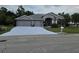 Charming home featuring a three-car garage, well-manicured lawn, and tasteful landscaping at 4351 Winding Oaks Cir, Mulberry, FL 33860
