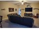 Spacious living room has a ceiling fan, a plush leather couch, and decorative fish decor on the walls at 4351 Winding Oaks Cir, Mulberry, FL 33860