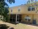Backyard view of the house featuring a screened in patio and mature trees at 436 Hammerstone Ave, Haines City, FL 33844
