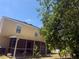 Backyard featuring a screened in patio with mature trees providing shade and privacy at 436 Hammerstone Ave, Haines City, FL 33844