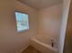 Bright bathroom featuring a garden tub and a window bringing in natural light at 436 Hammerstone Ave, Haines City, FL 33844