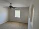 A bedroom with neutral carpeting, window, and ceiling fan at 436 Hammerstone Ave, Haines City, FL 33844