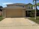 Inviting two-story home featuring an attached two-car garage and a well-manicured lawn at 436 Hammerstone Ave, Haines City, FL 33844