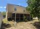 Two-story home showcasing a patio with backyard, enhanced by lush greenery and an air conditioning unit at 436 Hammerstone Ave, Haines City, FL 33844