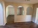 Inviting living room with arched doorways and wood-look flooring throughout the home at 436 Hammerstone Ave, Haines City, FL 33844