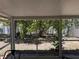 Enclosed patio with views of a backyard featuring mature trees, offering a serene outdoor space at 436 Hammerstone Ave, Haines City, FL 33844