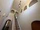 Carpeted stairway leading to arched openings with views of hardwood-look flooring below at 436 Hammerstone Ave, Haines City, FL 33844