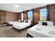 Spacious bedroom featuring three beds, exposed brick, and natural light at 4530 Narrative Ln, Kissimmee, FL 34746
