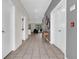 Long hallway with neutral tile flooring, gray accent wall, and access to multiple rooms in the home at 4530 Narrative Ln, Kissimmee, FL 34746