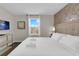 Bright main bedroom featuring a king bed, decorative wallpaper, and a window with bright sunlight at 4530 Narrative Ln, Kissimmee, FL 34746