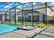 Relaxing pool and spa area with sun loungers and manicured landscaping in screened enclosure at 4530 Narrative Ln, Kissimmee, FL 34746