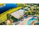 Aerial view of a sand volleyball court next to a pool with lush landscaping and lounge chairs at 4530 Narrative Ln, Kissimmee, FL 34746
