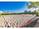 Sandy community volleyball court surrounded by a trimmed green hedge on a sunny day at 4530 Narrative Ln, Kissimmee, FL 34746
