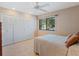 Bright bedroom features neutral walls, tile flooring, closet, and a bright window view at 5083 Eaglesmere Dr # A12, Orlando, FL 32819