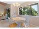 Sunlit dining area featuring a round table, white chairs, large windows, and views into the living room at 5083 Eaglesmere Dr # A12, Orlando, FL 32819