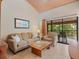 Bright living room with sliding glass doors to patio, tile floors, and comfortable seating at 5083 Eaglesmere Dr # A12, Orlando, FL 32819