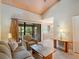 Bright living room featuring a vaulted ceiling, neutral paint, and sliding glass doors leading to an outdoor balcony at 5083 Eaglesmere Dr # A12, Orlando, FL 32819