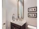 Elegant powder room featuring a marble countertop, decorative mirror, and stylish fixtures at 524 Lanark Ct, Orlando, FL 32806