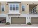 Townhome featuring three garage doors and upper story windows, offering ample parking and natural light at 524 Lanark Ct, Orlando, FL 32806