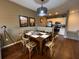 Cozy dining area with wooden table set, stylish light fixture, and adjoining kitchen at 5370 Diplomat Ct # 107, Kissimmee, FL 34746