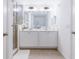Well-lit bathroom with double sinks, a large mirror, a glass shower, and white cabinets for ample storage at 665 Longboat Dr, Davenport, FL 33896