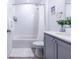 Bright bathroom featuring a shower with white tiling, a gray vanity with a modern countertop, and neutral walls at 665 Longboat Dr, Davenport, FL 33896