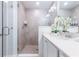 Modern bathroom featuring a glass-enclosed shower, a sleek vanity with a quartz countertop, and elegant white orchids at 665 Longboat Dr, Davenport, FL 33896