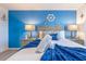 Beautiful bedroom with a nautical theme, plush bedding, and a decorative anchor on a calming blue wall at 665 Longboat Dr, Davenport, FL 33896