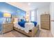 Nautical-themed bedroom with a decorative ship wheel, cozy wood furnishings, and a calming blue accent wall at 665 Longboat Dr, Davenport, FL 33896